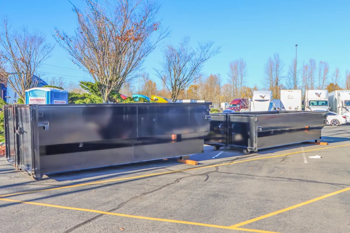 Professional dumpster rental service with roll-off container on residential driveway in Howland Center